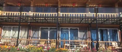 A traditional wooden building with a balcony and large windows.