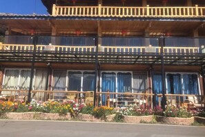 Un bâtiment traditionnel en bois, doté d’un balcon et de grandes fenêtres.