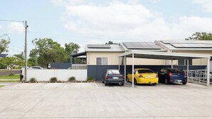 Un espace de stationnement couvert où trois voitures sont garées sous un abri.