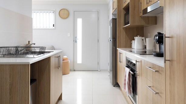 A modern kitchen with wooden cabinets, stainless steel appliances, and a white countertop. - Clean 1 Bdr Apt w/ AC & Kitchen | Parking | 139F1 (Rocklea)