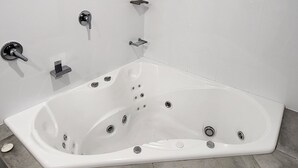 Une salle de bain moderne avec une baignoire îlot, une douchette à main et des toilettes intégrées.