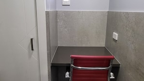 A small office space with a desk, chair, and an air conditioning unit mounted on the wall. - Jesmond Small Studio (Jesmond)