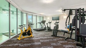 A gym with cardio machines, a bench press, and a weight machine.