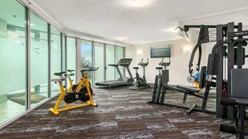A gym with cardio machines, a bench press, and a weight machine.
