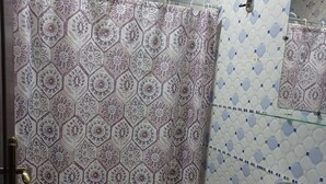 A bathroom with a toilet, a sink, and a shower curtain with a geometric pattern. - Cozy, Peaceful & Clean Studio Only 300 MAD (Ifrane)