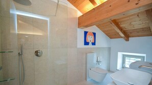 A modern bathroom with a shower, toilet, and sink.