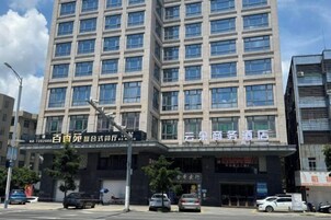 A multi-story building with a commercial ground floor, featuring a large sign with Chinese characters, multiple windows, and a few parked cars in front.