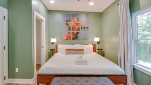 A bedroom with a bed, bedside lamps, a ceiling fan, and a window with curtains. - Luxe 4-Bed Retreat w/ Game Room & Deck – 10 Min to Downtown (Nashville)