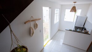A modern kitchen with white cabinets, a black countertop, and a hanging plant. - Beachfront House with Sea Views, Pool and Independent Suites Pet Friendly (Touros)