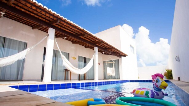 A swimming pool with inflatable toys and a hammock. - Beachfront House with Sea Views, Pool and Independent Suites Pet Friendly (Touros)
