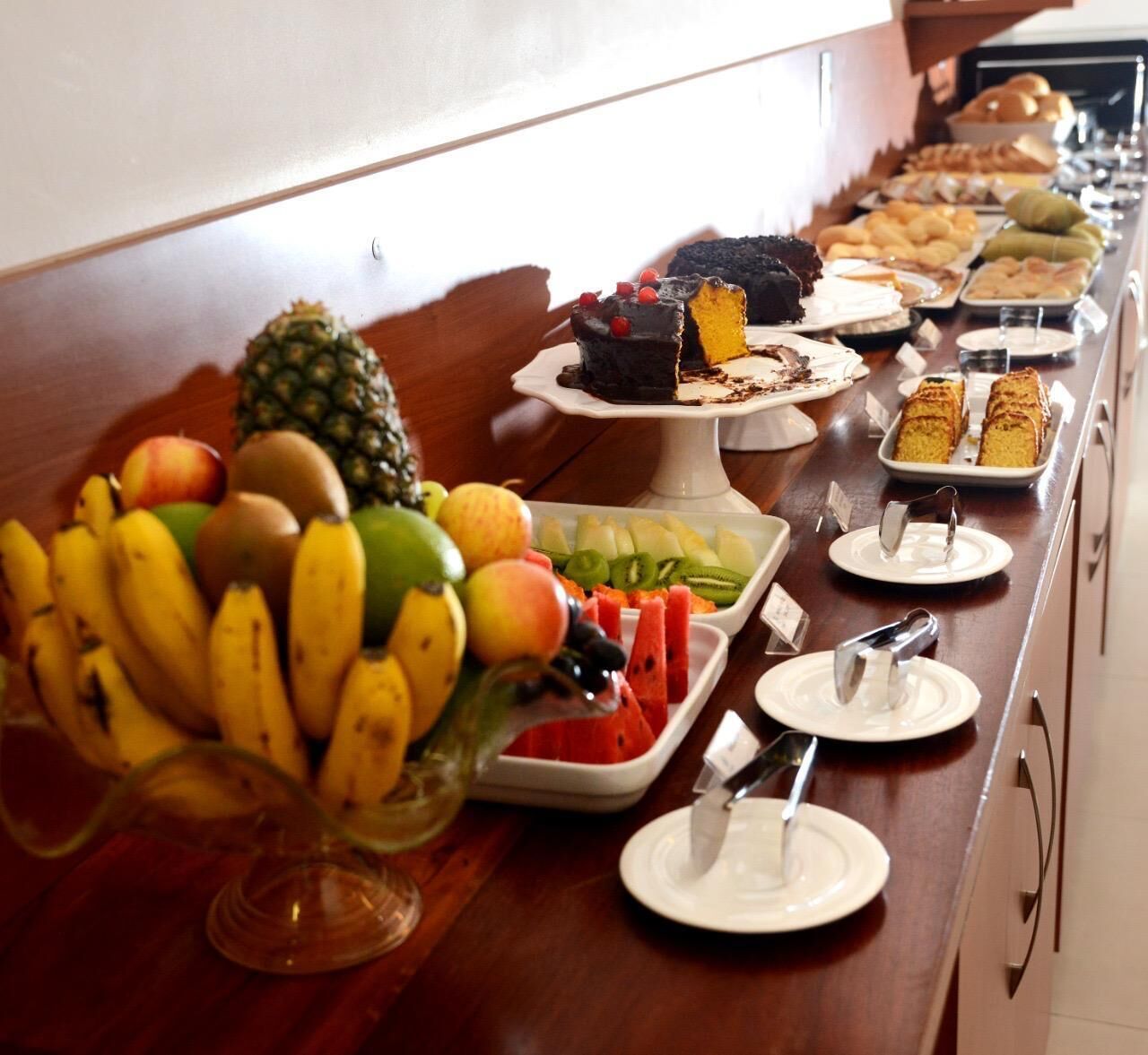 A buffet with various fruits, pastries, and desserts.