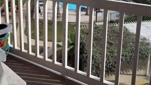 A balcony with a view of a swimming pool, palm trees, and a beach. - Isle B Back Cozy 1-bedroom condo with WiFi, AC in amazing Galveston (Galveston)