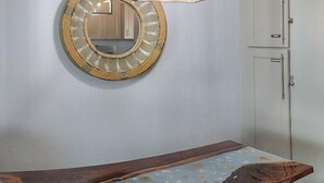A room with a wooden bench, a round mirror, and a cabinet. - Isle B Back Cozy 1-bedroom condo with WiFi, AC in amazing Galveston (Galveston)
