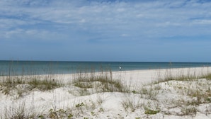 A beach with sand dunes and a clear sky.