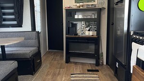 A compact kitchenette with a coffee maker, a refrigerator, and a microwave.