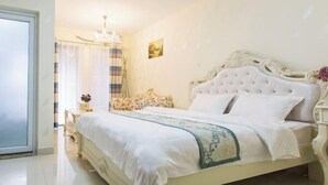 Una cama bien hecha con una colcha blanca y verde, un candelabro y un cuadro en la pared.