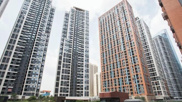 Un edificio residencial alto con múltiples pisos, grandes ventanales y un diseño arquitectónico moderno.