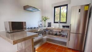 A kitchen with a microwave, stove, sink, and refrigerator.