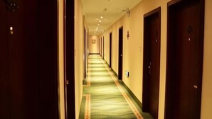 A hotel hallway with carpeted floors, wooden doors, and recessed lighting. - GreenTree Inn Kunshan Shimao Square Hotel (Kunshan)