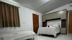 Une chambre à coucher avec un lit, un canapé, une armoire et une porte.