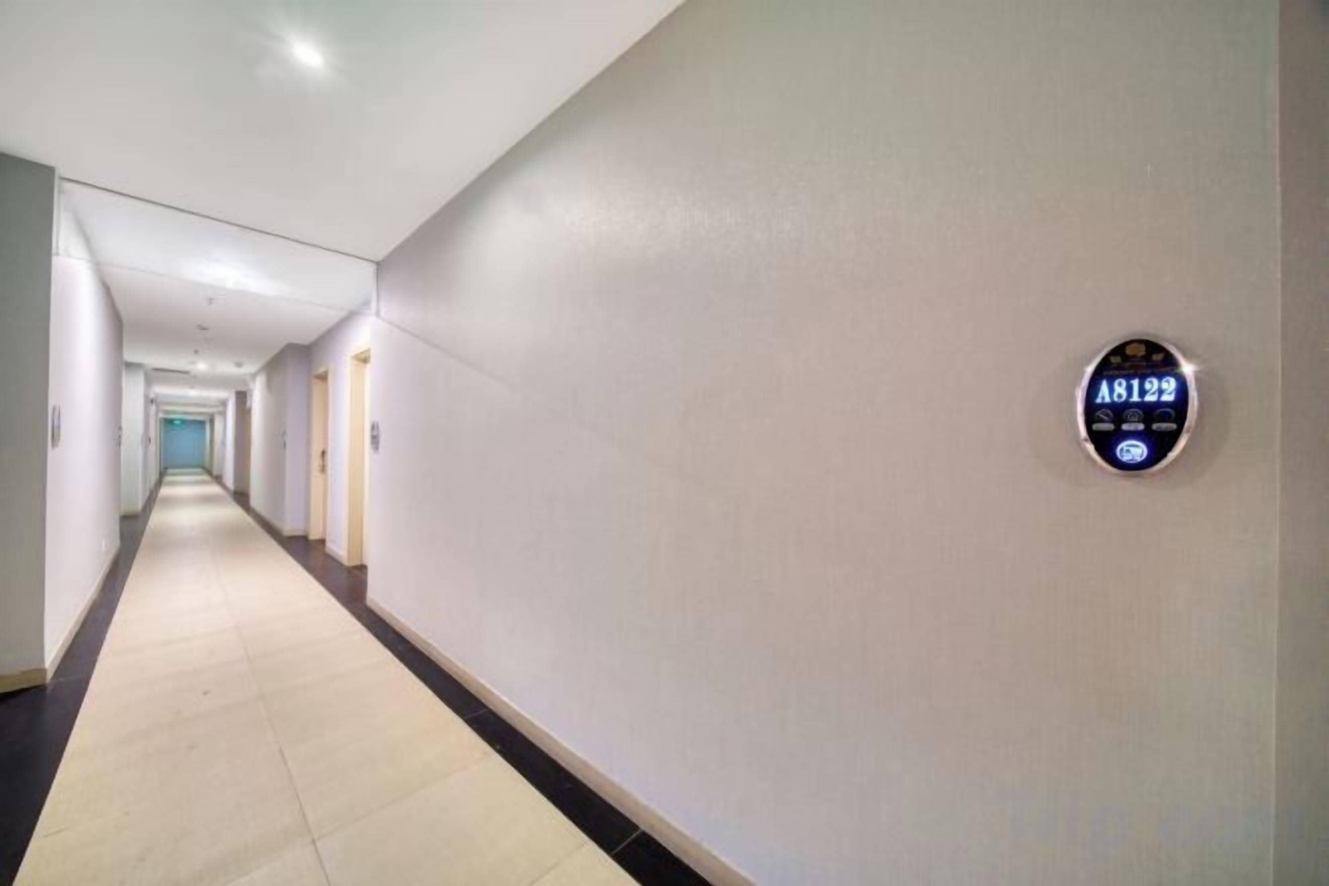A long, narrow hallway with a sign on the wall indicating room number A8192.