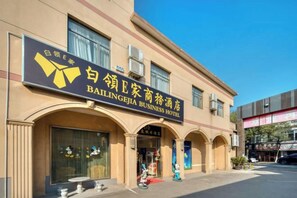 A building with a sign for Baillengejia Business Hotel. - Q+ Bailing Ejia Business Hotel (Shanghai International Tourism Resort) (Shanghai)