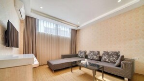 Ein modernes Wohnzimmer mit einer Sofagarnitur, einem Couchtisch und einem an der Wand montierten Flachbildfernseher.