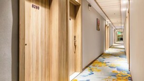 A hotel hallway with wooden doors numbered 8269, a floral carpet, and a straight corridor leading to a bright room at the end. - City 118 Chain Inn Qingdao Zhengyang Road Liqun (Qingdao)