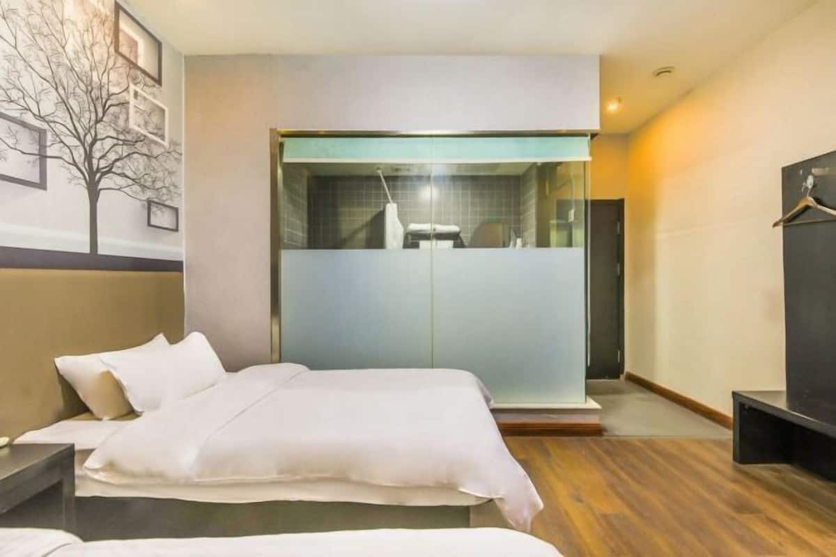 Una habitación de hotel con una cama, un armario y un espejo.