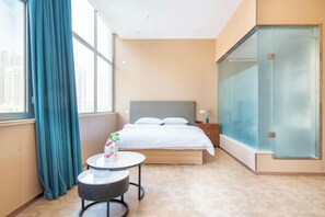 A hotel room with a bed, a small round table, a nightstand, a window with curtains, and a glass door. - City 118 Chain Inn Qingdao Zhengyang Road Liqun (Qingdao)