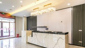 A hotel reception area with a marble counter, a chandelier, and a modern design. - City 118 Chain Inn Qingdao Zhengyang Road Liqun (Qingdao)