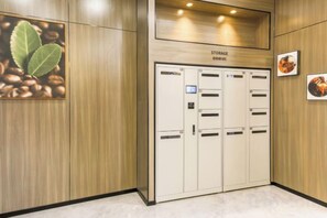 A storage room with multiple lockers and a wooden wall with a coffee bean picture. - City 118 Chain Inn Qingdao Zhengyang Road Liqun (Qingdao)