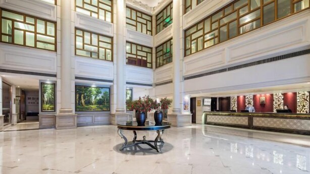 A spacious lobby with high ceilings, large windows, and a reception desk. - Shunhe Zaozhuang Hotel (Zaozhuang)