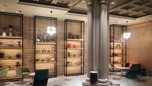 A lobby with a marble floor, modern furniture, and decorative shelves with vases. - Shunhe Zaozhuang Hotel (Zaozhuang)