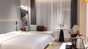A modern hotel room with two beds, a small table with a plant, a coffee maker, and a chair. - Shunhe Zaozhuang Hotel (Zaozhuang)