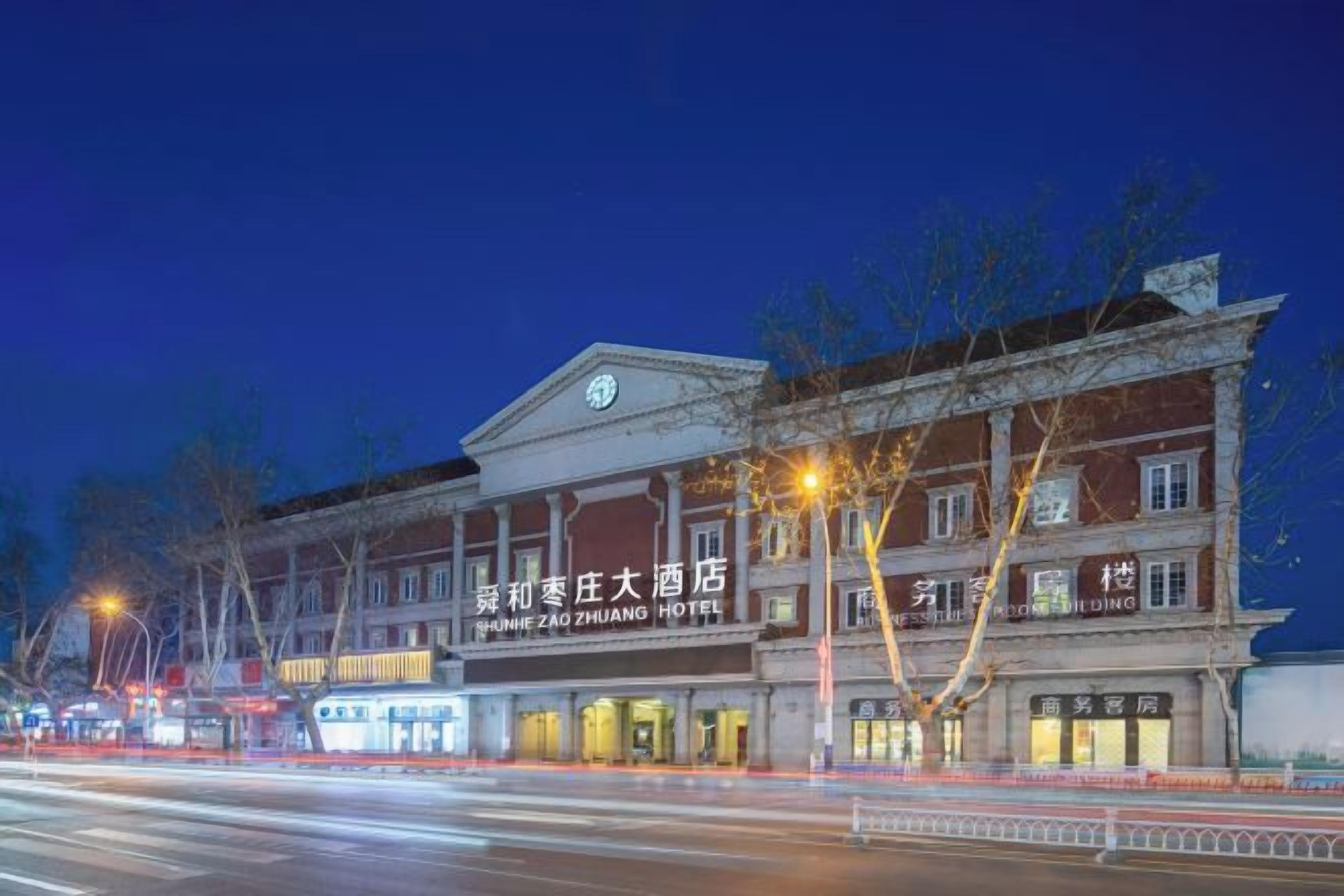 A historic building with signage for the 'Shunhe Zhuang Hotel' and 'Shunhe Zhuang Hotel' in English.