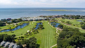 A golf course with multiple ponds, a large body of water, and a view of the ocean. - Luxury Villa, Club Access, Beach, Pet-Friendly (Seabrook Island)