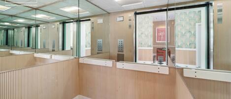 Un área de ascensor moderna con paredes espejadas y un estampado de cuadros.