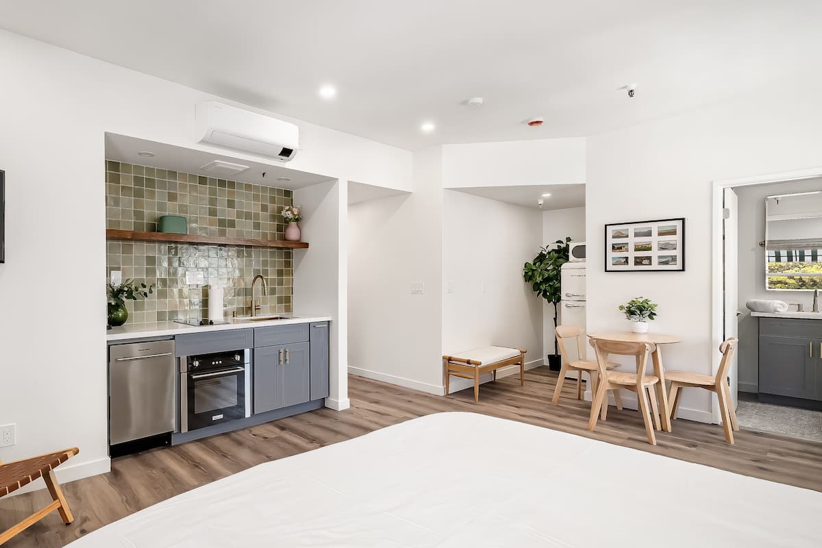 Una cocina moderna con armarios grises, horno empotrado y salpicadero de azulejos.