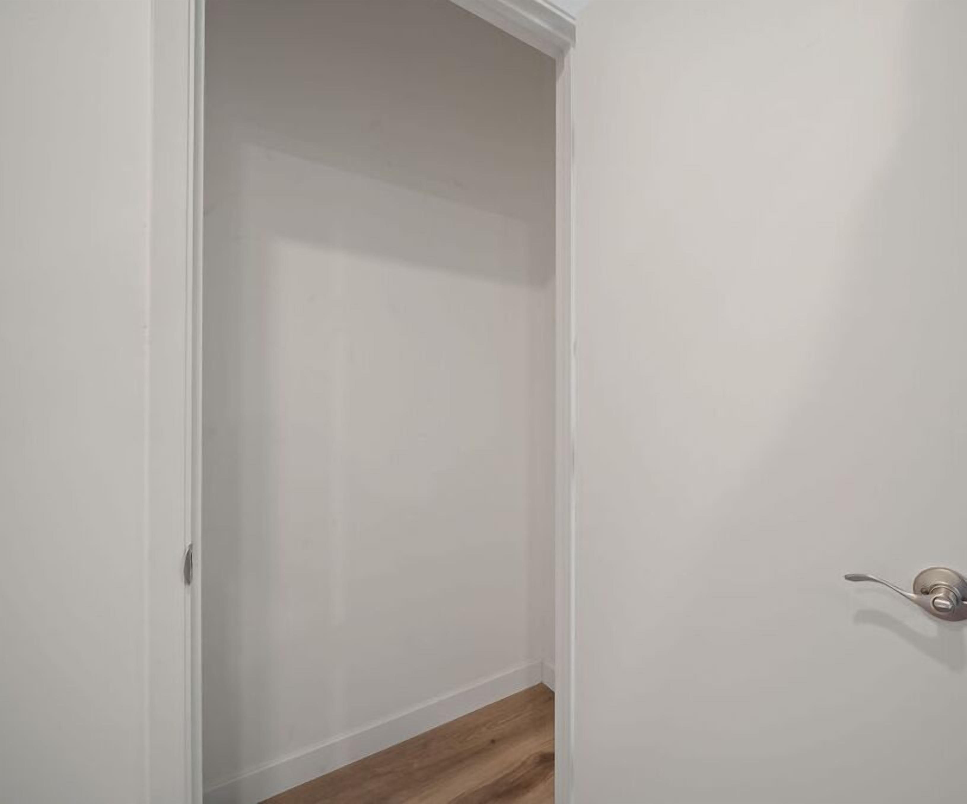 A closed white door with a silver handle and a wooden floor visible at the bottom.