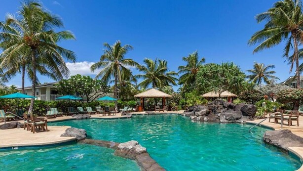 A pool surrounded by palm trees and lounge chairs. - Charming and immaculate, fully furnished 3-bedroom 3 bath townhouse in Ko'Olina! (Kapolei)