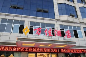 A hotel building with a prominent red sign and a logo.