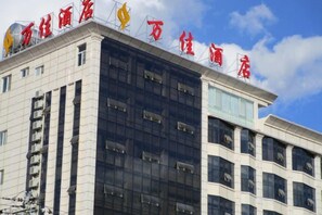Un edificio de hotel de varios pisos con un letrero llamativo en el techo.