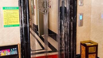 An elevator interior with a digital display, a handrail, and a floor indicator.