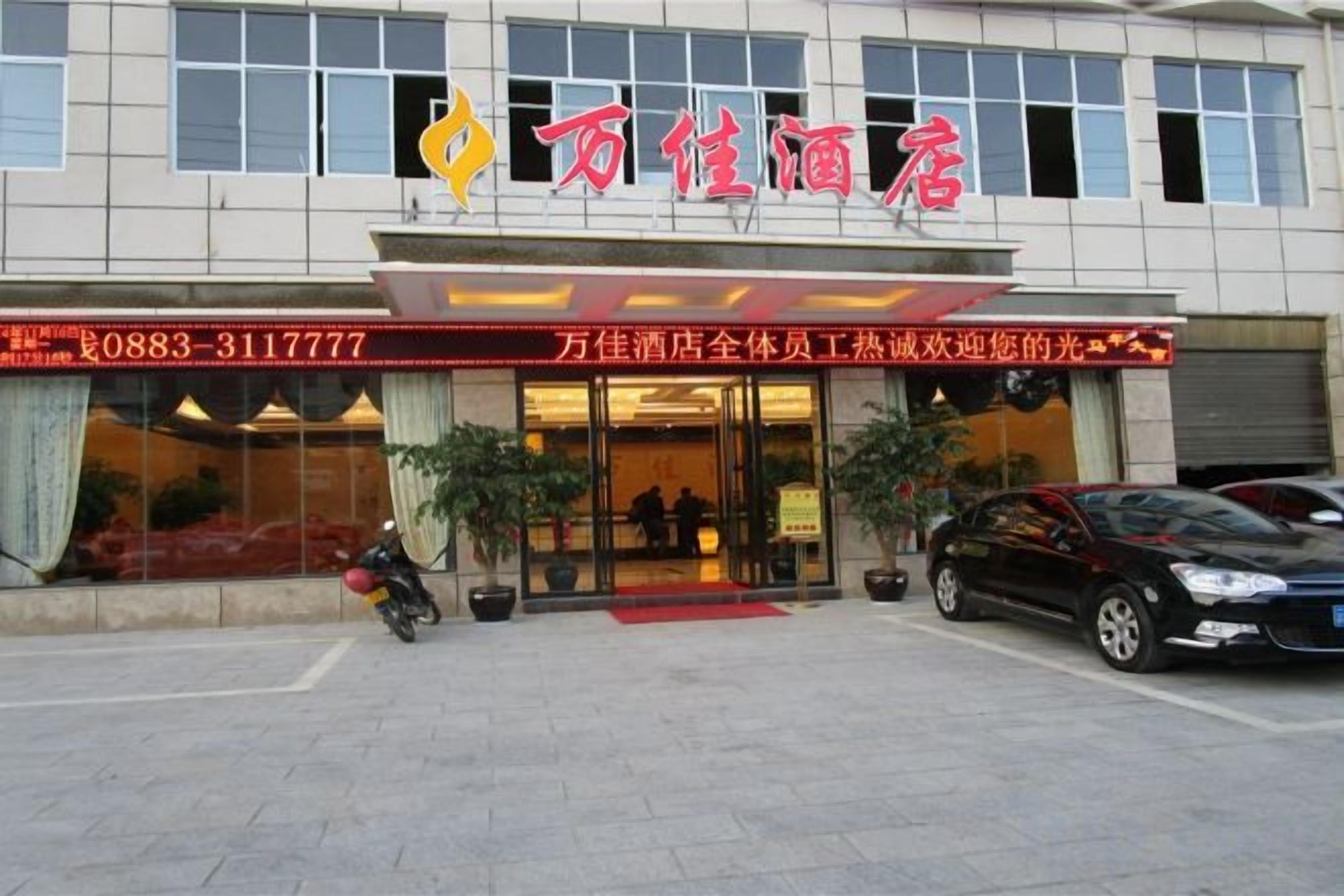 A hotel with a red awning and a large glass entrance.