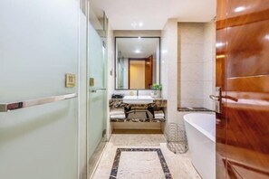 A modern bathroom with a marble sink, a bathtub, and a glass shower enclosure.