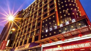 A multi-story hotel building with illuminated windows and a sign indicating it is a hotel. - Wan Yue Hotel (Jinjiang)