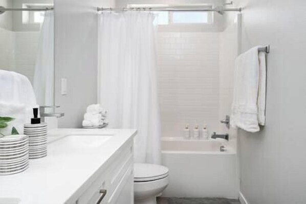 A modern bathroom with a white sink, toilet, and bathtub.