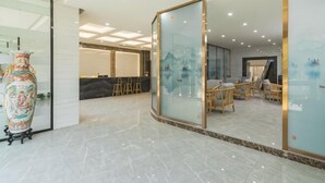A spacious lobby with a reception desk, seating area, and a large decorative vase. - Yading Boutique Hotel (Meishan Sansuxuan) (Meishan)