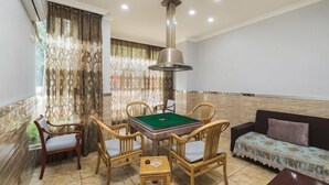 A room with a pool table, four chairs, a sofa, and a ceiling light fixture. - Yading Boutique Hotel (Meishan Sansuxuan) (Meishan)
